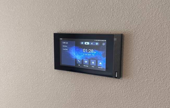 A digital thermostat is mounted on a wall.