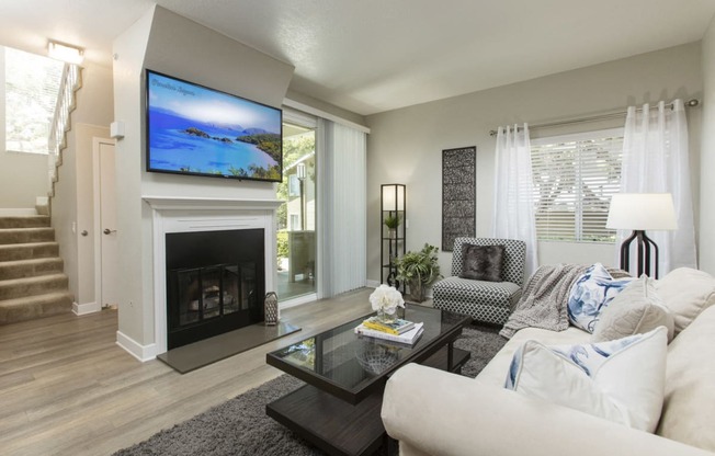 Living area with fireplace, TV, and sliding glass doors to balcony