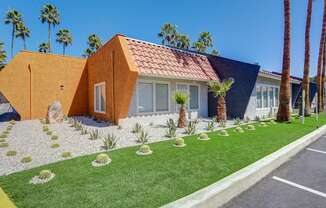 A house with a red tile roof and a yellow front yard.
