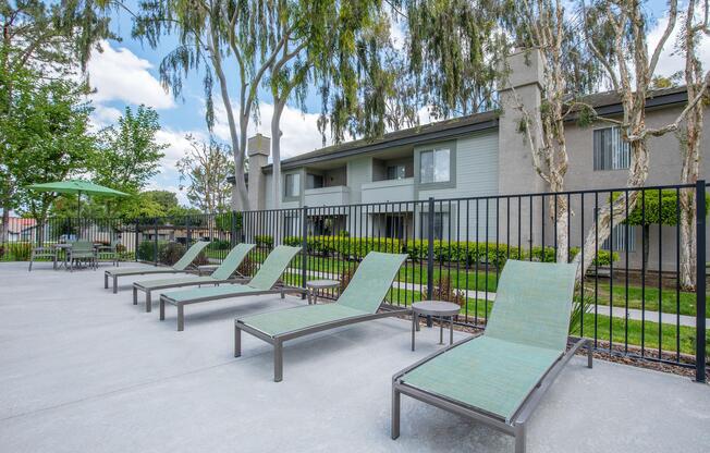 a group of lawn chairs sitting on top of a wooden fence