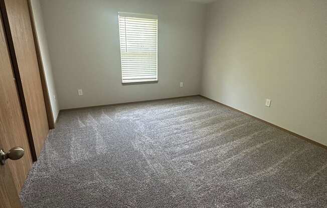 a room with a carpeted floor and a window
