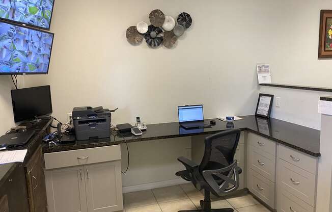 a desk with a computer and a printer on it at Colonial Apartments, Florida, 32808