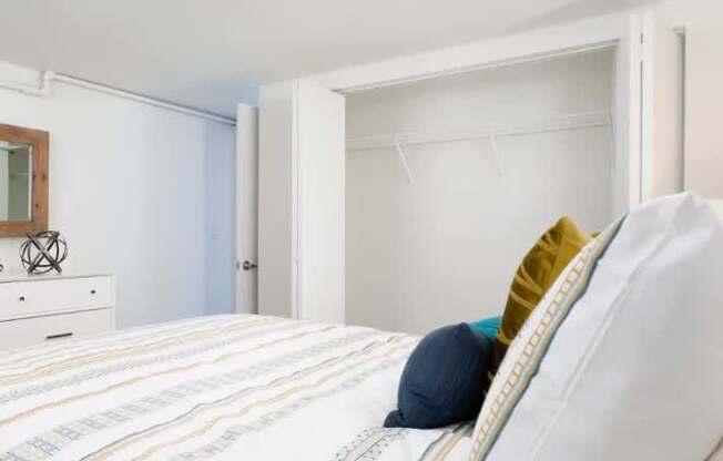 A bed with a white pillow and a striped comforter.