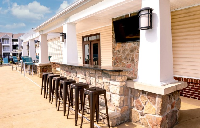a row of bar stools in front of a stone wall with a bar counter