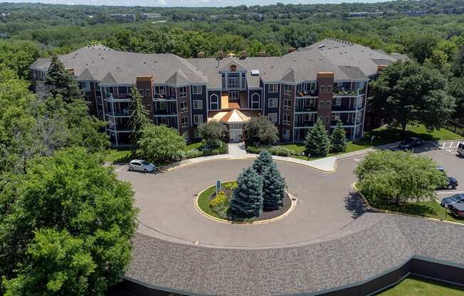 an aerial view of a large building with trees and a fountain