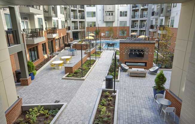 an open courtyard with benches and tables in an apartment building at Link Apartments® Calyx, Chapel Hill, NC 27517