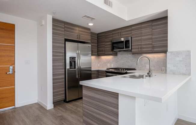 a kitchen with stainless steel appliances and a white counter top