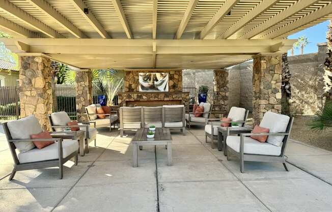 a covered patio with chairs and tables under a pergola