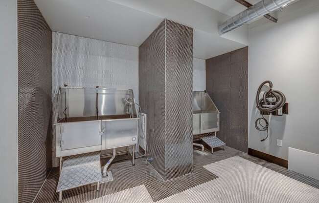 a bathroom with two stainless steel sinks and a urinal