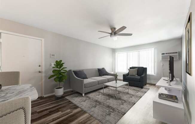 a living room with couches and a coffee table at Town & Country Apartments - Wixom, MI, Wixom