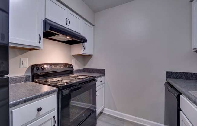 a kitchen with white cabinets and black appliances