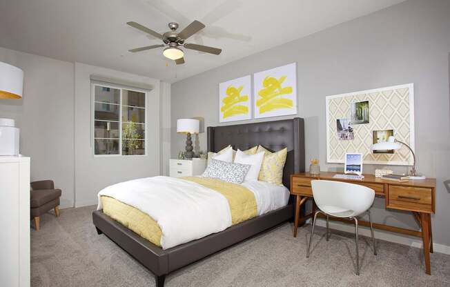 A bedroom with a bed, desk, and chair.