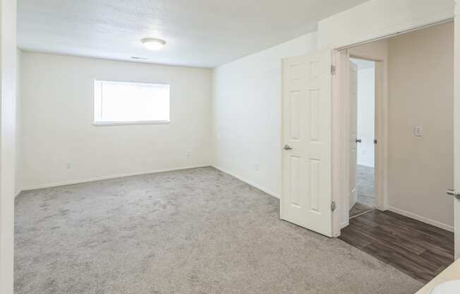 an empty living room with a door to a bathroom