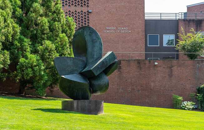 A large sculpture sits on a pedestal in front of the Rhode Island School of Design.