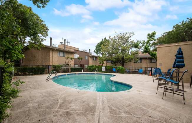 our apartments have a resort style pool with chairs and umbrellas