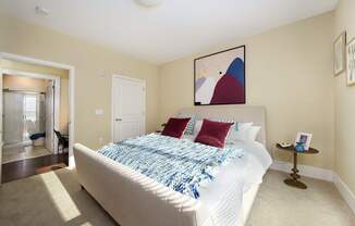 A bedroom with a bed, pillows, and a nightstand.