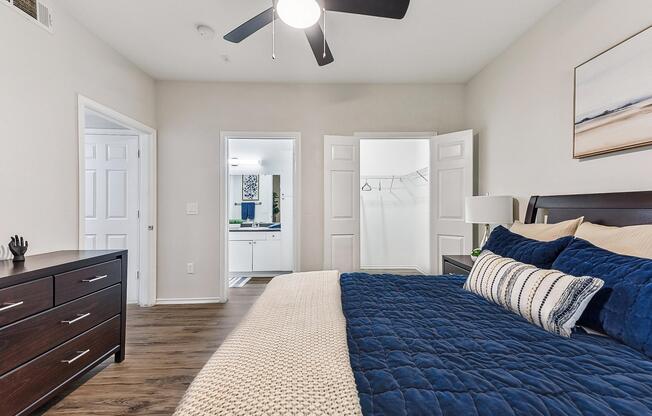 A bedroom with a large bed and a ceiling fan.