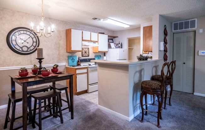 a kitchen and dining area with a large clock on the wall at The Summit Apartments, Memphis, Tennessee