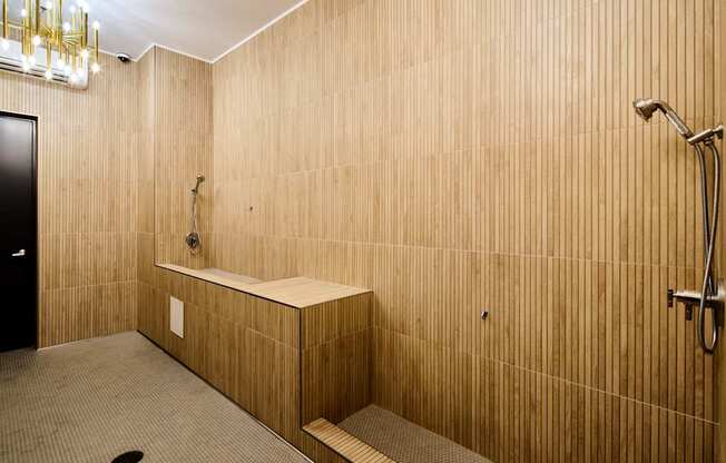 A bathroom with a wooden wall and a black door.