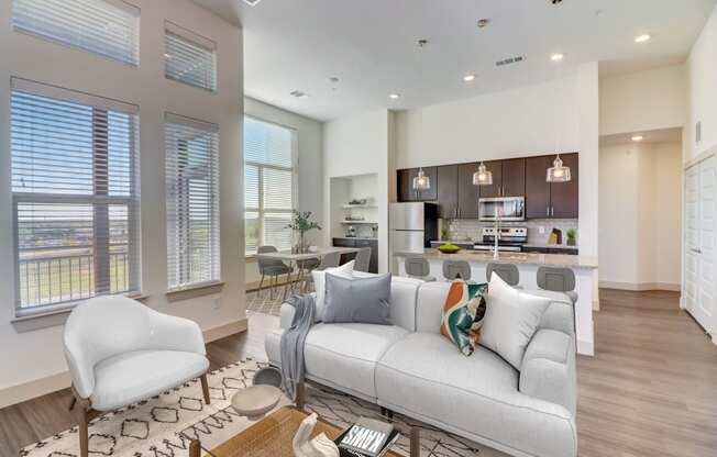 an open living room and kitchen with a couch and chairs