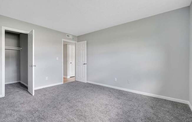 A room with a grey carpet and white walls.