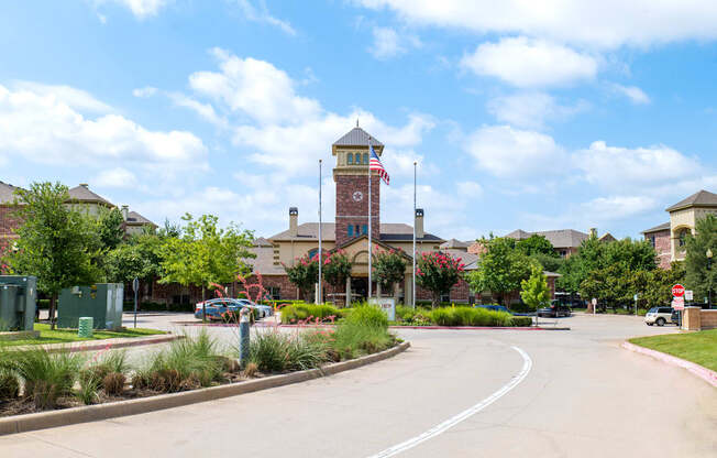 A street view of a town with a clock tower in the background.