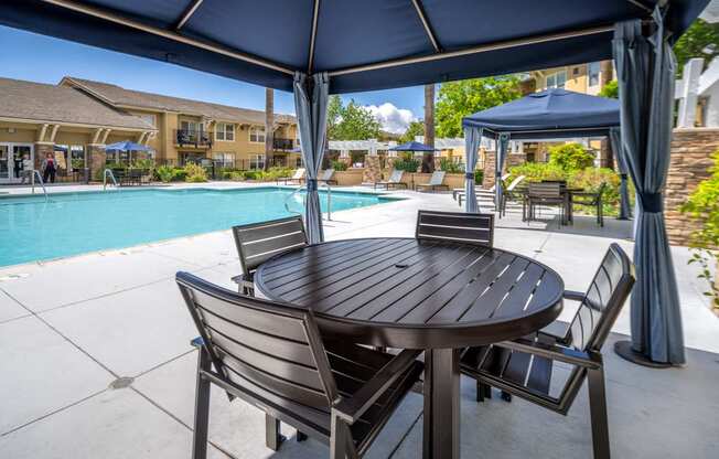 Pool area cabanas with tables and chairs at 55+ FountainGlen Temecula