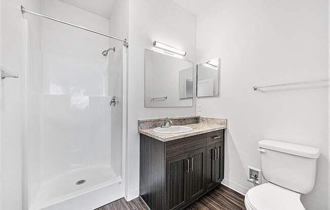 a bathroom with a shower toilet and a sink at Trade Winds Apartment Homes in Elkhorn, NE 68022
