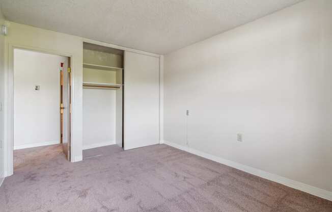 an empty living room with a door to a closet