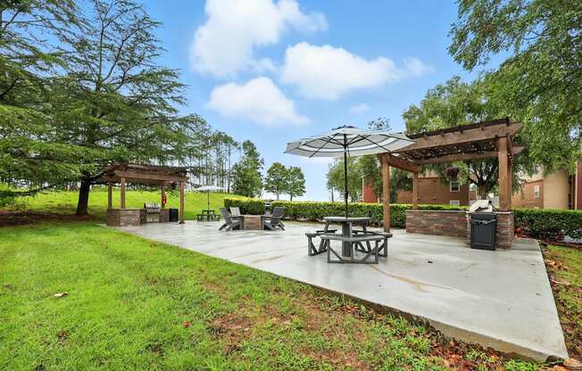 A picnic area with a table and chairs under a canopy.