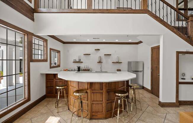 A kitchen with a bar and stools.