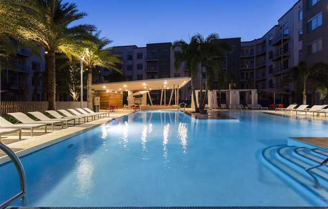 Illuminated pool at twilight with palm trees  at LandonHouse in Lake Nona