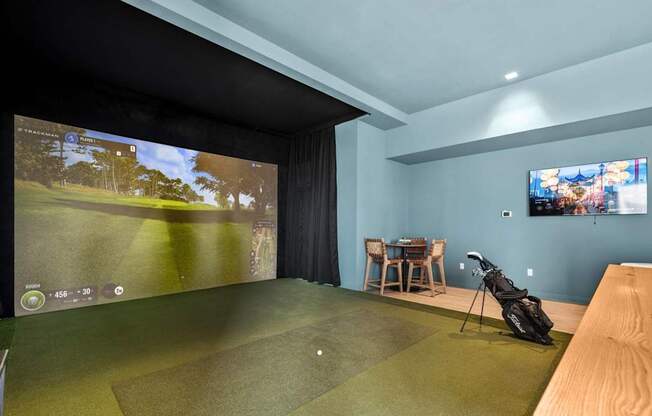 A golf simulator room with a screen showing a golf course.