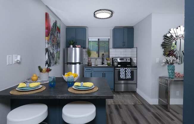 Fusion Las Vegas apartment kitchen with blue and yellow dinette place settings and modern console table with blue vase.