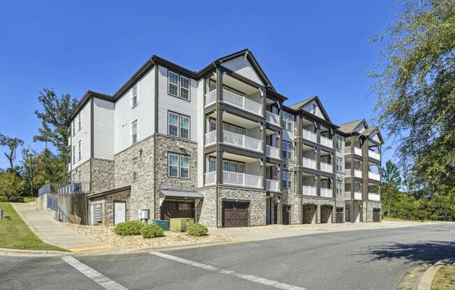 Shot of the exterior of one of the apartment building on the corner of a street at Evergreen at Southwood in Tallahassee, FL