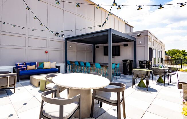 a patio area with tables and chairs and a television