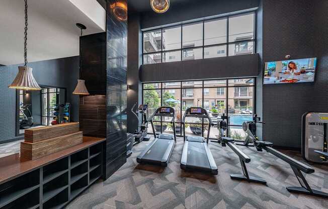 A gym with treadmills and a television.