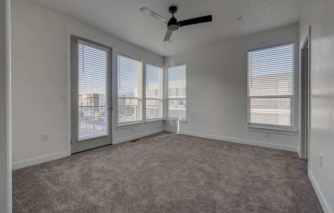 A room with a ceiling fan and large windows. at Reveal, Utah
