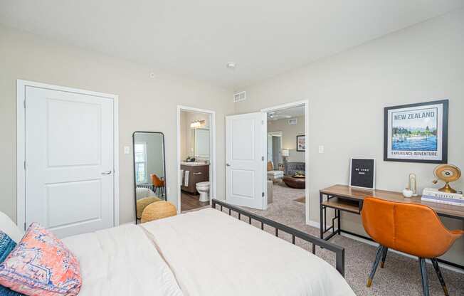 a bedroom with a bed and a desk with a mirror