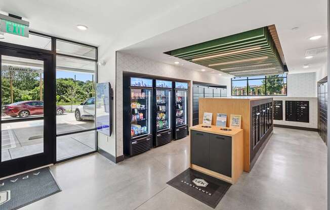 A modern office lobby with a reception desk and a view of the parking lot outside at Link Apartments® CYKEL Apartments, Charlotte, NC, 28208