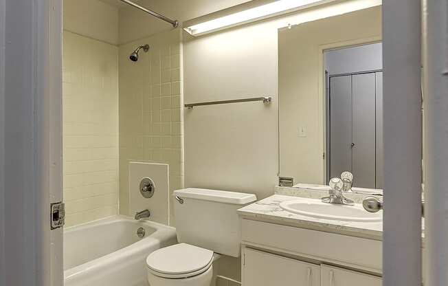 A white bathroom with a toilet, sink, and bathtub.