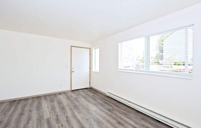 an empty room with white walls and a window