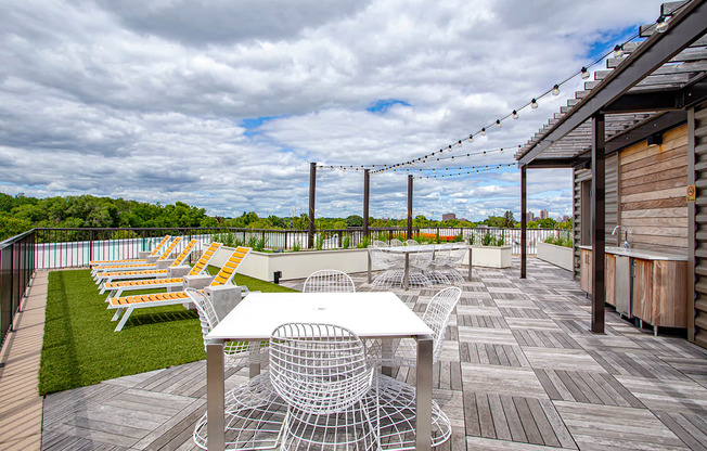 A wooden deck with a table and chairs overlooking a grassy area.