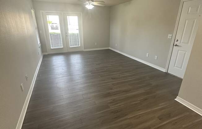 an empty living room with a hardwood floor