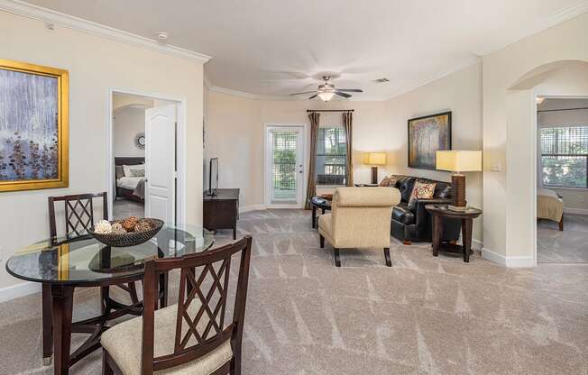A living room with a glass table and chairs.