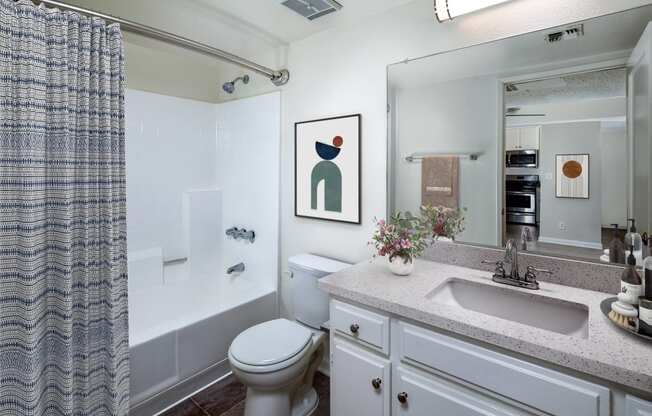 a bathroom with sink toilet and shower