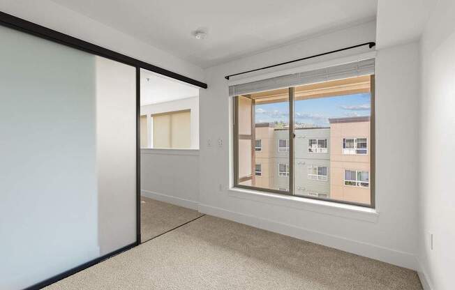 A room with a large window and a sliding door.