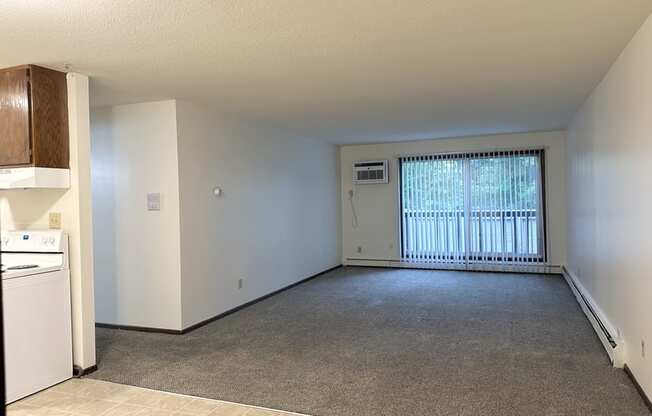 the living room and kitchen of an empty house with a large window