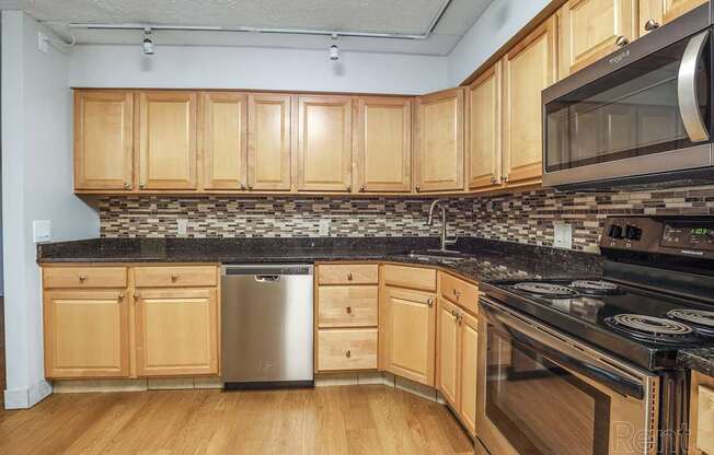 A kitchen with wooden cabinets and a black countertop.