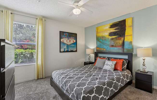 A bedroom with a large bed and a painting on the wall.